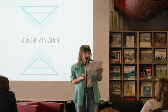 Man sieht die Poetry Slammerin Theresa Hahl im Schatten, im Hintergrund das Logo zur Veranstaltung Sowohl als Auch