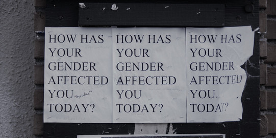 Man sieht drei DinA4 Blätter nebeneinander hängen mit dem Spruch "How has your gender affected you today?"
