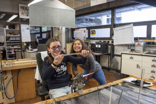 zwei Mädchen sind in einer Werkstatt und arbeiten zusammen mit viel Freude