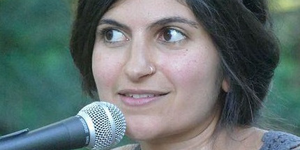 Eine junge Frau sitzt vor einem Mikrofon