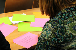 Eine Frau schreibt Notizen auf Post-its